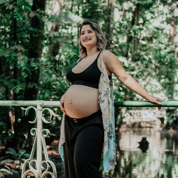 Person smiling peacefully outdoors in a natural setting.